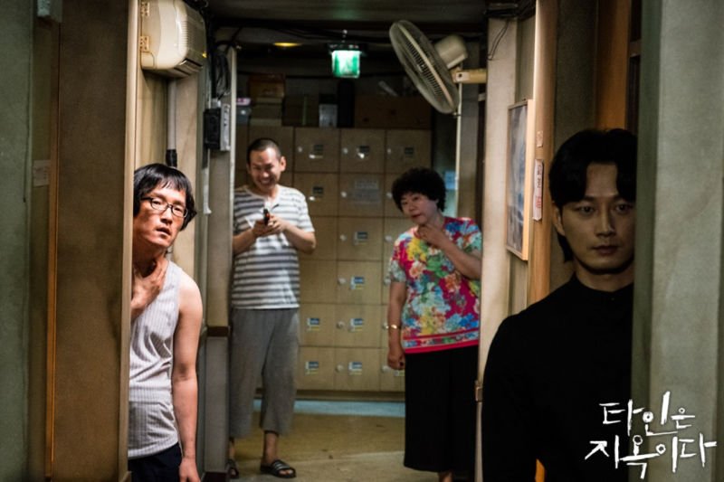 What is the meaning behind the end scene of “Strangers From Hell”? Did Seo  Moon-jo die? If yes, why did the detective see him in the elevator? Why did  it feel like